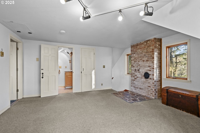 unfurnished living room featuring track lighting and carpet flooring