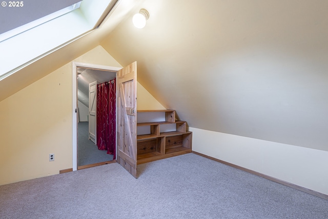 bonus room featuring carpet floors and vaulted ceiling with skylight