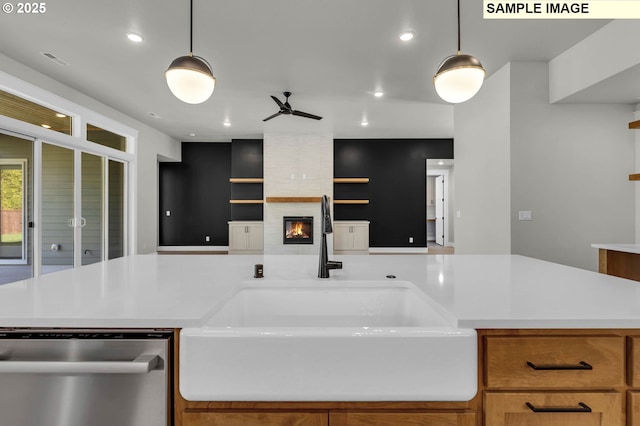 kitchen featuring pendant lighting, a fireplace, sink, stainless steel dishwasher, and ceiling fan