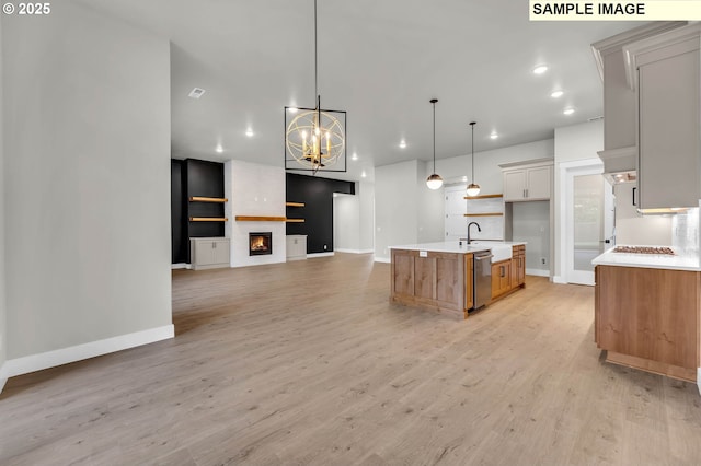 kitchen with a large island, light hardwood / wood-style flooring, white cabinetry, hanging light fixtures, and stainless steel dishwasher