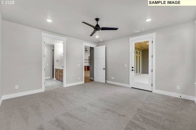 unfurnished bedroom featuring light carpet and ensuite bath