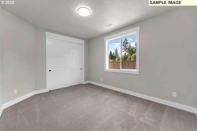 unfurnished bedroom with a closet, carpet flooring, and a textured ceiling