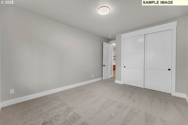 unfurnished bedroom with light colored carpet and a closet