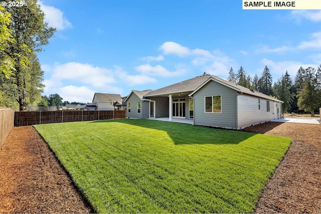 rear view of property featuring a patio area and a lawn