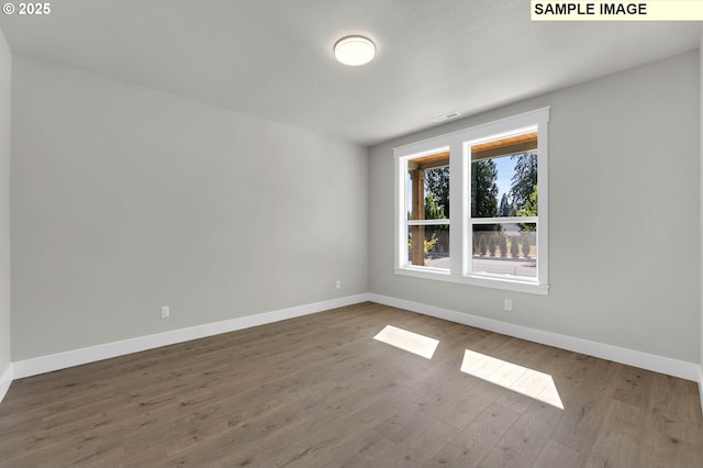 unfurnished room featuring hardwood / wood-style flooring