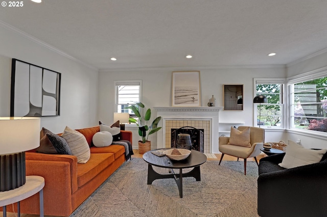 living room with a fireplace, recessed lighting, and ornamental molding