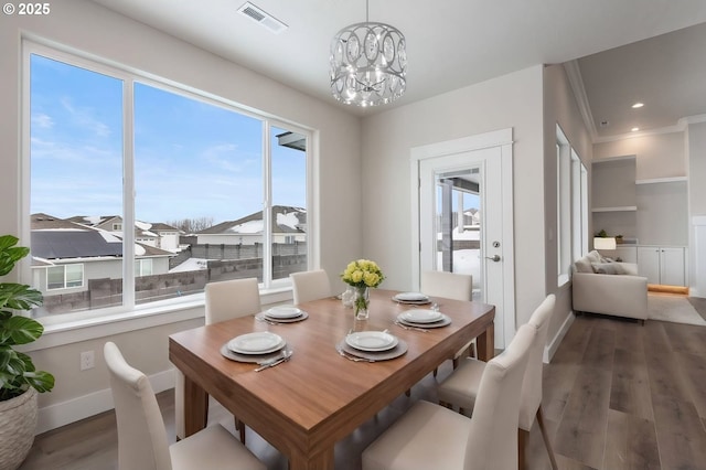 dining space with a notable chandelier and dark hardwood / wood-style floors