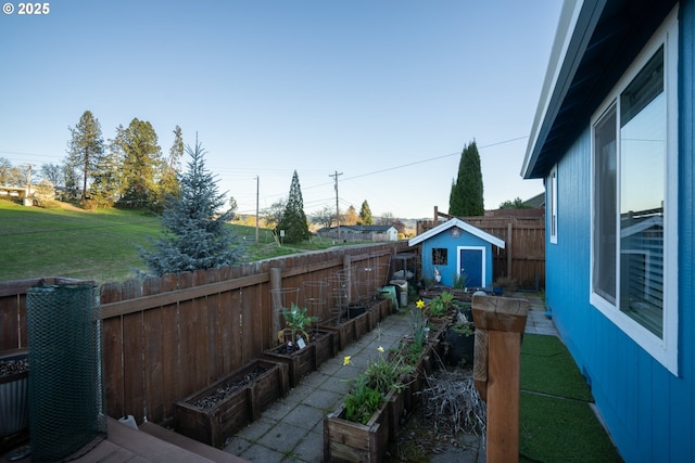 721 N Summerwood St, Roseburg, OR 97471 - view of yard with a storage unit, a fenced backyard, an outdoor structure, and a vegetable garden