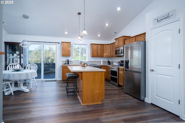 721 N Summerwood St, Roseburg, OR 97471 - kitchen with light countertops, a kitchen island, a kitchen breakfast bar, dark wood-style floors, and stainless steel appliances