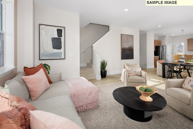 living room with recessed lighting, baseboards, stairs, and light wood finished floors