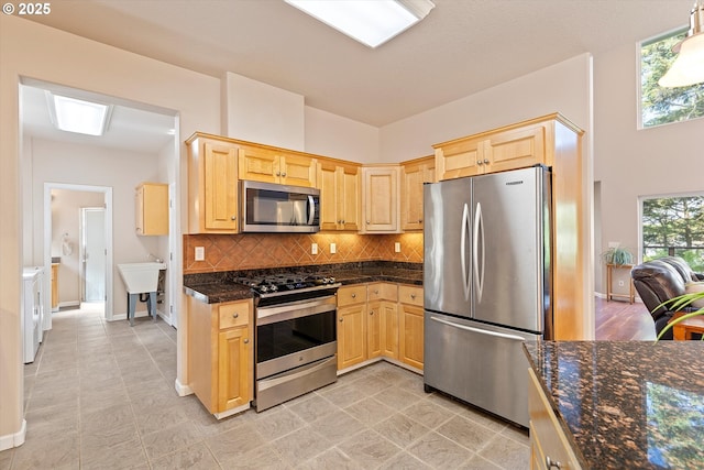 5220 SW Neal Ave, Waldport, OR 97394 - kitchen featuring stainless steel appliances, light brown cabinetry, decorative backsplash, and a sink
