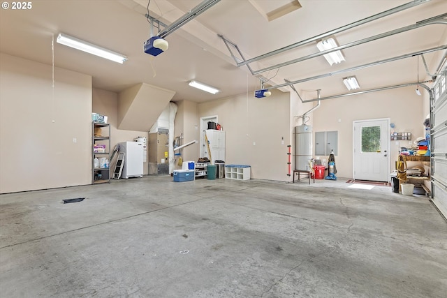 5220 SW Neal Ave, Waldport, OR 97394 - garage with a garage door opener, strapped water heater, and freestanding refrigerator
