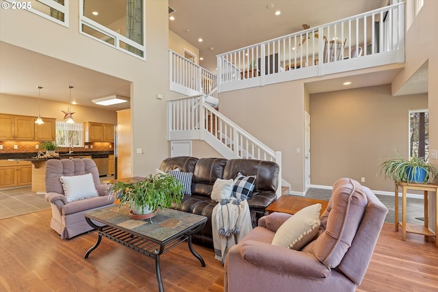 5220 SW Neal Ave, Waldport, OR 97394 - living area featuring a high ceiling, stairs, light wood-style flooring, healthy amount of natural light, and recessed lighting