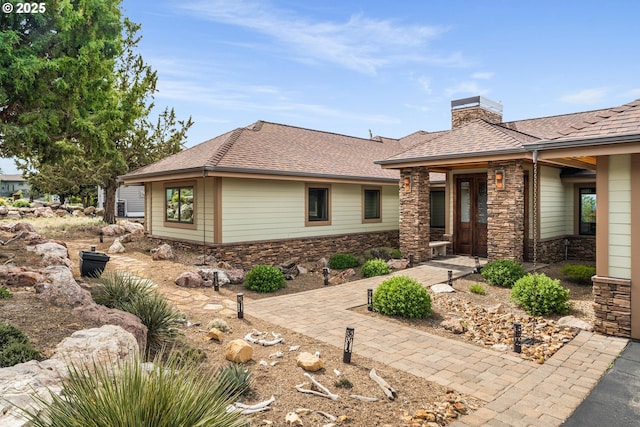 10715 Rockside Ct, Redmond, OR 97756 - view of front facade with stone siding, a chimney, and a shingled roof