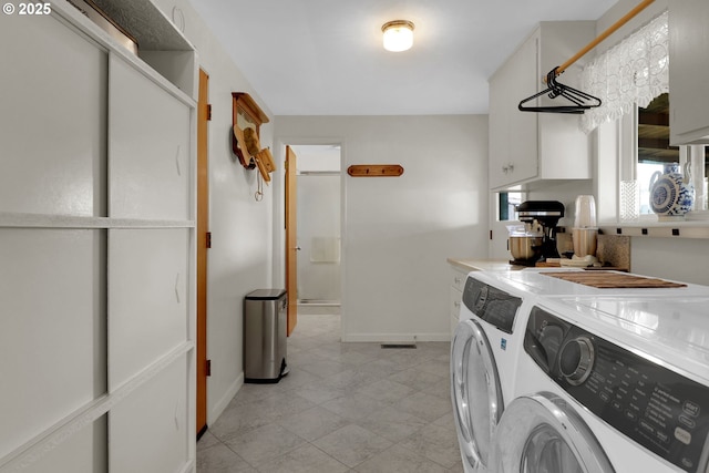 laundry area with laundry area, separate washer and dryer, and baseboards