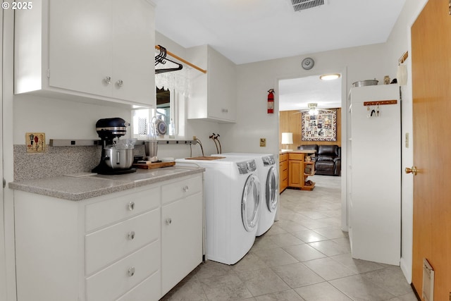 washroom with light tile patterned floors, laundry area, visible vents, and separate washer and dryer