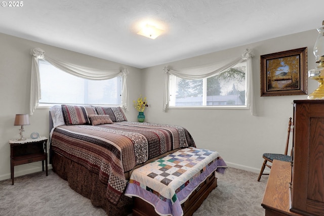 bedroom featuring light colored carpet and baseboards