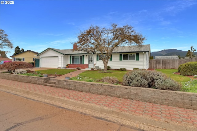 single story home featuring a front lawn, an attached garage, fence, and driveway