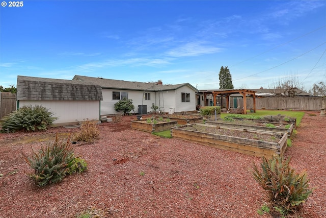 back of house with fence and a garden