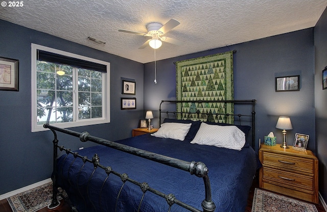 bedroom with ceiling fan and a textured ceiling