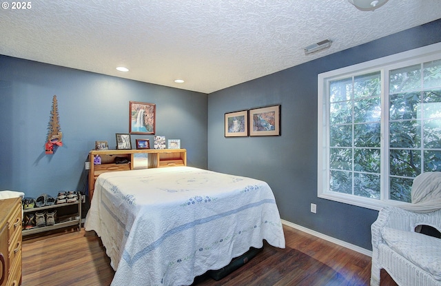 bedroom featuring dark hardwood / wood-style flooring and a textured ceiling