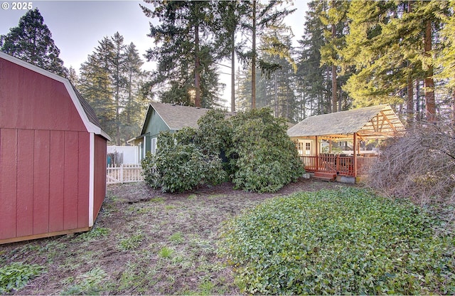 view of yard featuring an outdoor structure and a deck