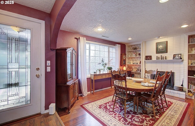 dining room with hardwood / wood-style floors and a textured ceiling