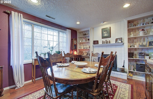 dining space featuring hardwood / wood-style floors and a textured ceiling