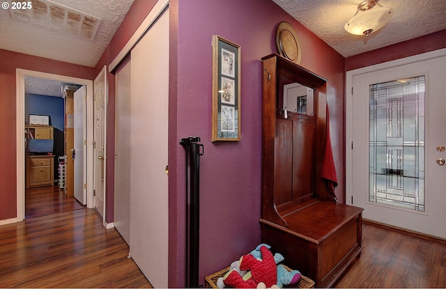 hallway featuring dark wood-type flooring and a textured ceiling