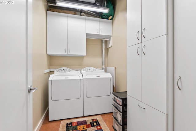 1025 NW Couch St Unit 613, Portland, OR 97209 - clothes washing area with light wood-style flooring, baseboards, washing machine and clothes dryer, and cabinet space
