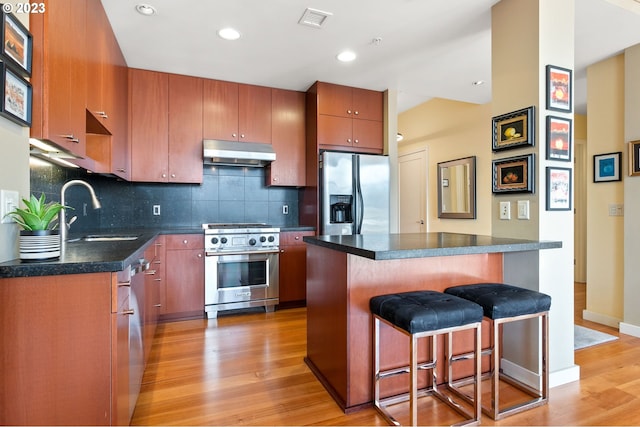1025 NW Couch St Unit 613, Portland, OR 97209 - kitchen with visible vents, a sink, appliances with stainless steel finishes, under cabinet range hood, and light wood-style flooring