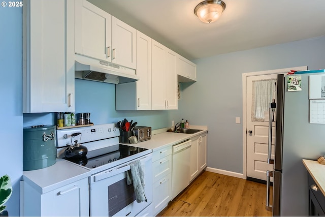 kitchen featuring light countertops, a sink, white cabinetry, under cabinet range hood, and white appliances