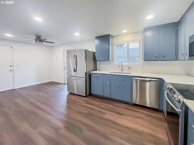 kitchen featuring appliances with stainless steel finishes, dark wood-type flooring, a sink, and recessed lighting