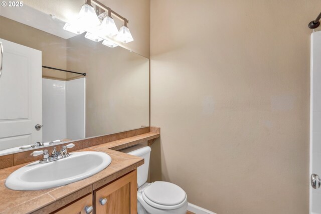 full bathroom with toilet, vanity, and walk in shower