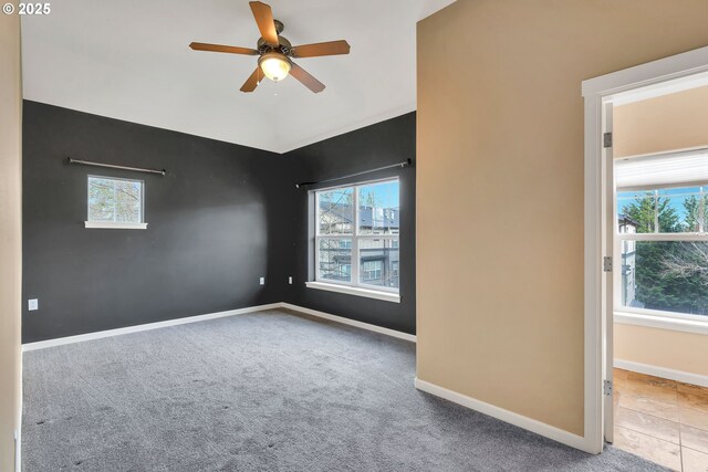 unfurnished room featuring baseboards, a ceiling fan, and carpet
