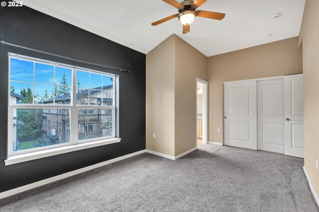 unfurnished bedroom with a closet, carpet, baseboards, and ceiling fan