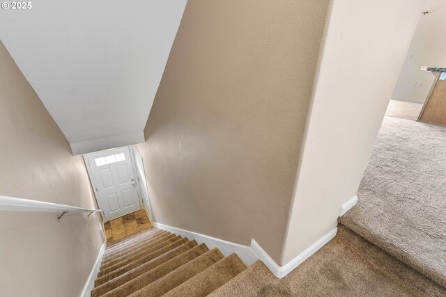 staircase with baseboards and carpet
