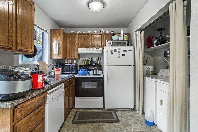 7820 SW 17th Dr, Portland, OR 97219 - kitchen with white appliances, under cabinet range hood, a sink, washing machine and dryer, and brown cabinetry