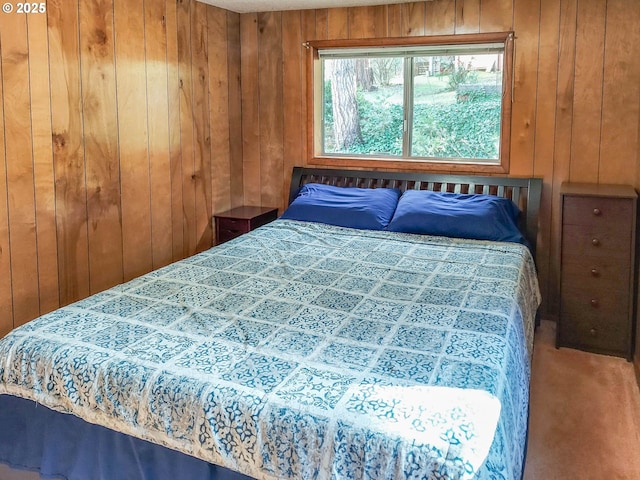 carpeted bedroom featuring wood walls