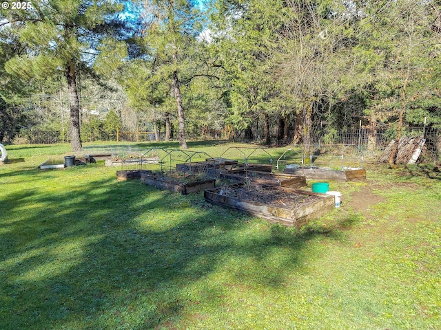 view of yard featuring a vegetable garden and a wooded view