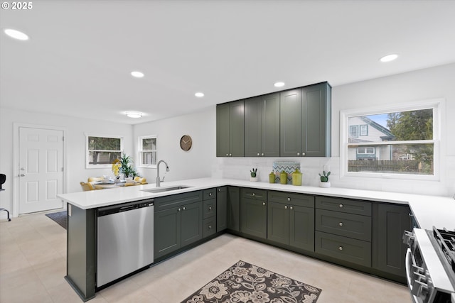 kitchen featuring appliances with stainless steel finishes, kitchen peninsula, sink, and backsplash