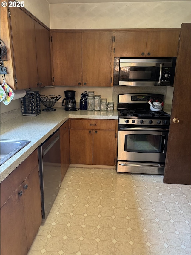 10930 SW 61st Ave, Portland, OR 97219 - kitchen featuring appliances with stainless steel finishes, light flooring, light countertops, and brown cabinets