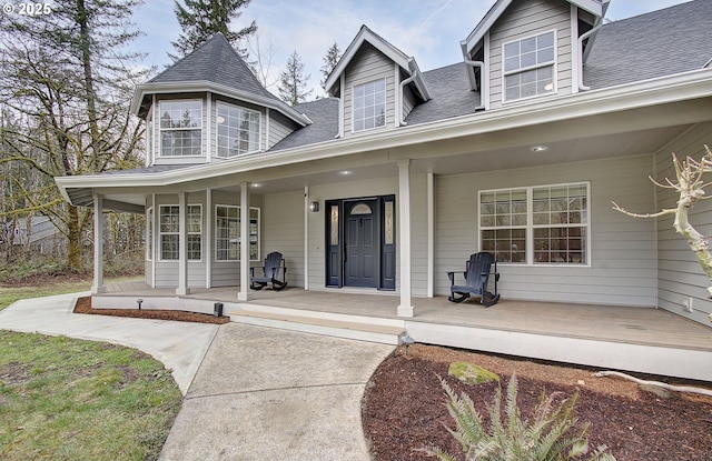 view of front of property featuring covered porch and a shingled roof