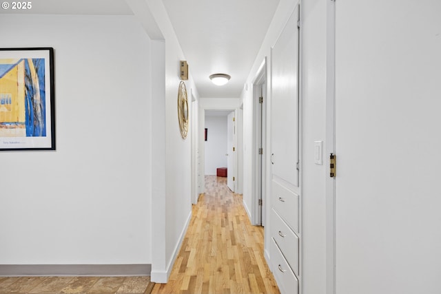 hallway with light hardwood / wood-style floors