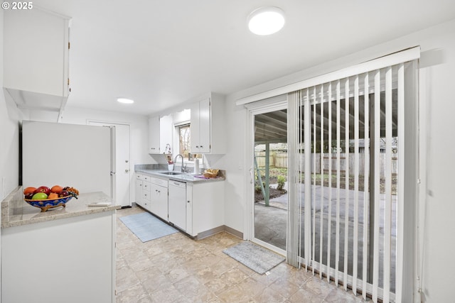 kitchen featuring white cabinetry, sink, white appliances, and light stone countertops