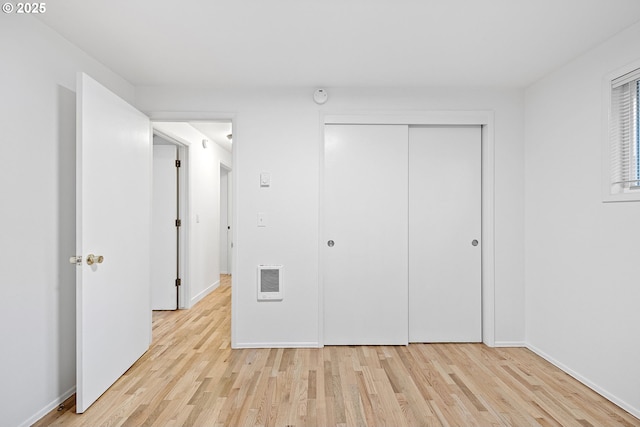 unfurnished bedroom with a closet and light wood-type flooring