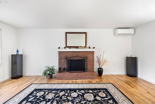 living room featuring wood-type flooring, a wall mounted air conditioner, and a fireplace