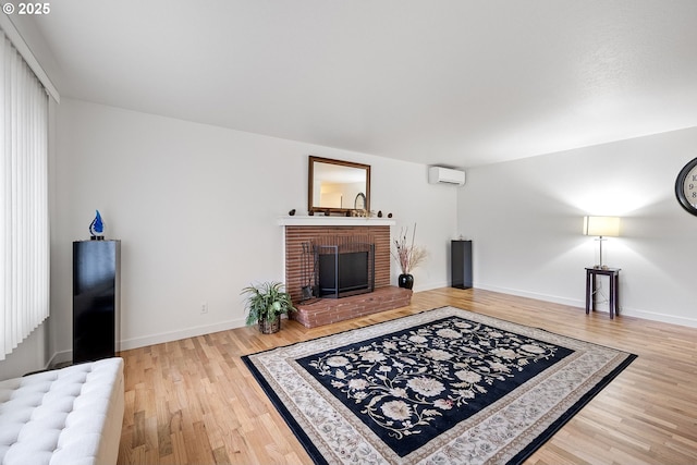 living room featuring a fireplace, hardwood / wood-style floors, and a wall unit AC