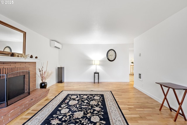 living room featuring wood-type flooring, a wall mounted air conditioner, and a fireplace