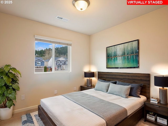 carpeted bedroom with visible vents and baseboards